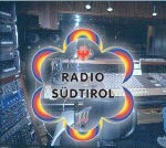 Logo of Radio Südtirol in front of a recording studio.